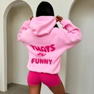 Detail of pink hooded sweatshirt featuring bold THATS SO FUNNY printed text on the back