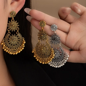 Detail of vintage bohemian tassel earrings with hollow carved floral patterns