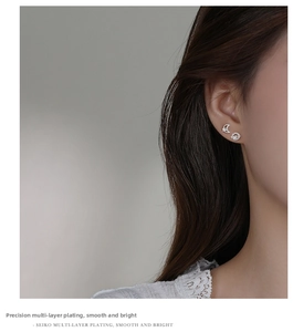 Detail view of asymmetric S925 silver moon and star earrings with polished zircon inlay