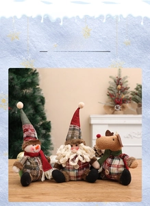 Close-up of rustic Christmas plush dolls with plaid fabric, buttons, and knit scarves