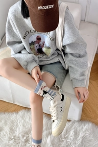 Detail of white cotton mid-calf socks with blue stripes and cute black cat cartoon pattern