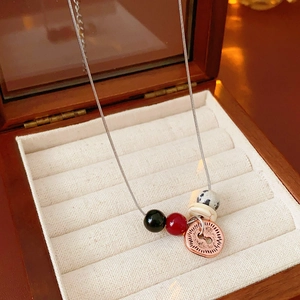 Macro view of bohemian necklace with stone beads and coin pendant in a wooden box