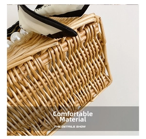 Detail of hand-woven straw bag featuring large white pearls and a stylish printed silk scarf