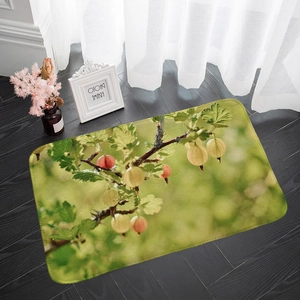 Absorbent flannel rectangular floor mat with green berry and leaf pattern on wood floor