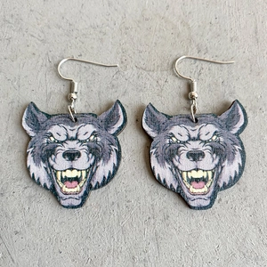 Quirky wooden wolf head print earrings with silver hooks on a grey textured background