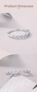 Macro detail of a scalloped silver ring with round diamonds on a minimal background