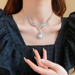 Gros plan du collier avec pendentif goutte d'eau en cristal sur un mannequin