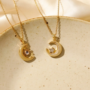 Chic gold celestial necklaces with sun moon and star pendants on ceramic plate