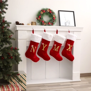 Dettaglio calze di Natale rosse con lettere dorate glitterate N Y M X e pelliccia sintetica