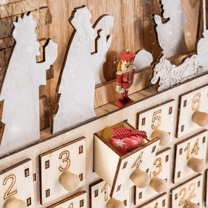 Detail of wooden Christmas advent calendar with open drawer and nutcracker decoration