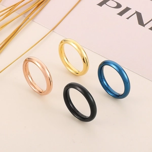Vista macro di anelli in acciaio lucido da 4mm in oro rosa, oro, nero e blu metallo