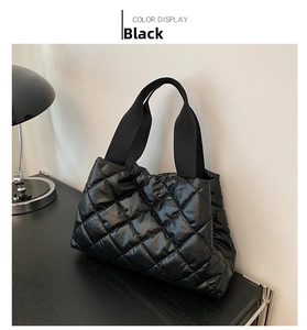Détail du sac fourre-tout matelassé noir avec coutures en losange et poignées