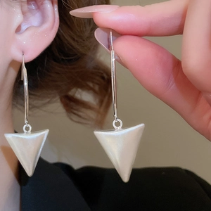 Detailed macro view showing the 18k brushed metal finish and white 3D triangle earring pendant