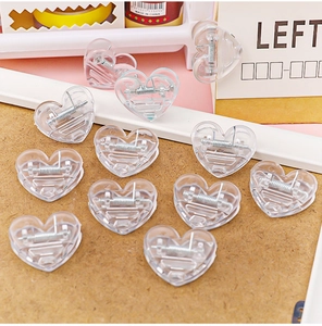 Macro detail of transparent heart-shaped clips made of durable clear plastic