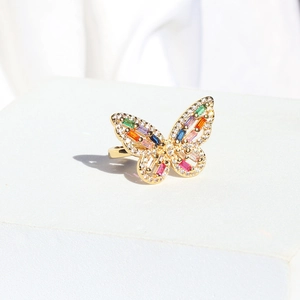 Detailed macro view of a golden butterfly ring featuring colorful zircon stones on a pedestal