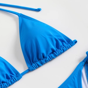 Detail view of royal blue bikini top featuring halter neck ties and pleated cup design