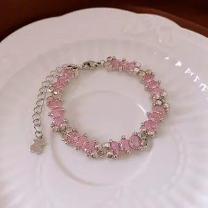 French style oval pink zircon bracelet in silver finish with bear charm on a white plate