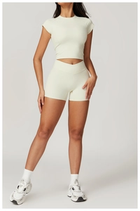 Full body view of women's beige quick-dry yoga set with V-cross waistband shorts