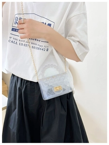 Transparent PVC jelly bag with pearl handle and gold chain strap shown on model