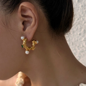 Vintage gold C-shaped earrings with embossed texture, pearls, and a green gemstone
