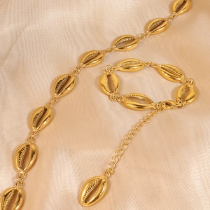 Golden seashell jewelry set featuring an ocean-themed necklace and adjustable bracelet