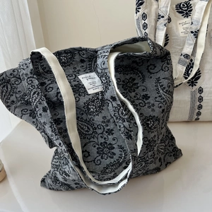 Detail of paisley and ethnic embroidery on cotton linen tote bags with webbing handles