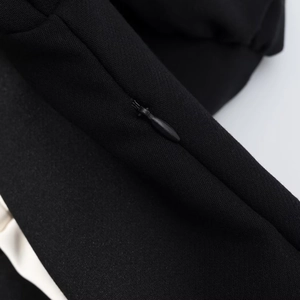 Détail de la fermeture éclair invisible sur une robe noire élégante pour femme