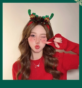 Detail of Christmas headband with green sequin antlers and festive colorful tinsel accents