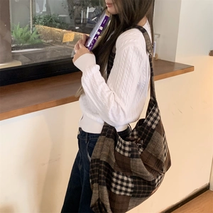 Dettaglio della grande borsa tote scozzese vintage in un ambiente da caffè