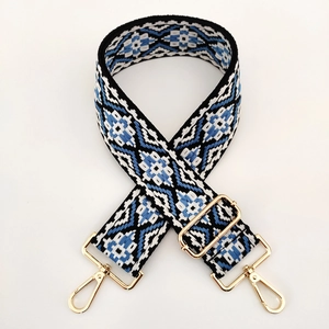 Close-up of geometric ethnic pattern wide strap with rotating gold metal hooks