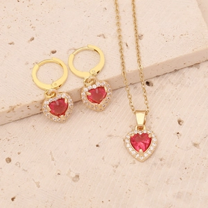 Detail of gold-plated necklace and earrings set with red heart-shaped zircon stones