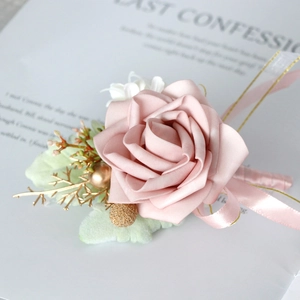 Elegant dusty pink rose boutonniere with golden branch accents and silk ribbon
