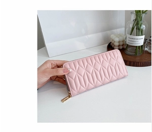 Detail of pink quilted long wallet with diamond stitching and gold zipper closure