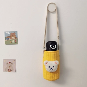 Detailed view of yellow quilted water bottle bag with 3D teddy bear and beige strap