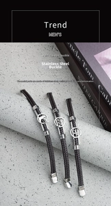 Close-up of brown braided leather bracelets with engraved stainless steel charms on stand