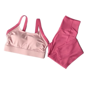 Two-piece yoga set with pink sports bra and high-waisted leggings featuring side pockets