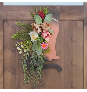 Detailed view of floral cat-shaped wooden wreath decoration on a natural rustic wood door