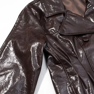 Detailaufnahme der braunen glänzenden PU-Lederjacke mit Revers und zweireihigem Knopfdetail