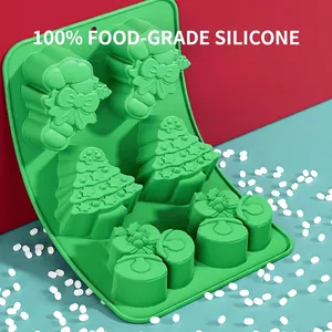 Green Christmas silicone baking mold with festive trees and bells on a red-blue background