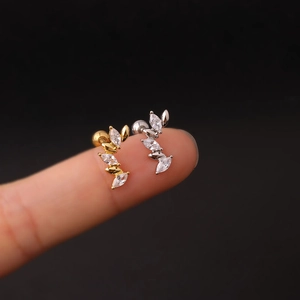 Macro shot of 16G stainless steel curved ear cartilage studs with marquise-cut zircons
