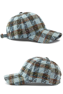 Detail van vintage tweed honkbalpet met blauwe ruittextuur en zes-paneels constructie