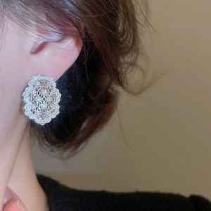 Gros plan de boucles d'oreilles ovales en zircon avec détails en dentelle sur un mannequin