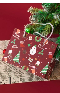 Detail of red Merry Christmas paper gift bag with snowman and tree motifs on vintage background