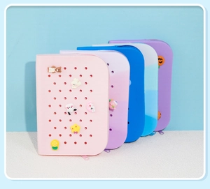 Detail showing five colorful DIY silicone pencil cases with decorative cartoon charms