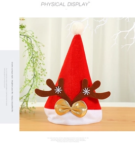 Gros plan d'un bonnet de Noël festif orné de bois de renne et d'un nœud doré élégant.