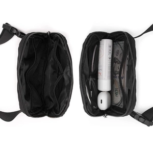 Internal view of black nylon waist bag showing mesh compartments and storage capacity