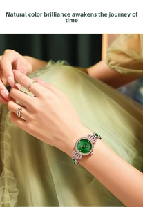 Detail of rose gold quartz watch with emerald green dial and diamond-set bracelet on wrist