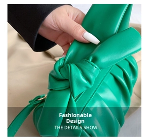 Detail of a green pleated cloud bag featuring soft synthetic leather and knotted bow detail
