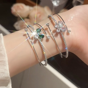 Dettaglio di bracciali aperti a tre strati in argento con quadrifoglio in zircone verde