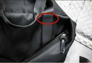 Detail of waterproof nylon travel bag with JIAHAILE logo on leather patch and metal zipper